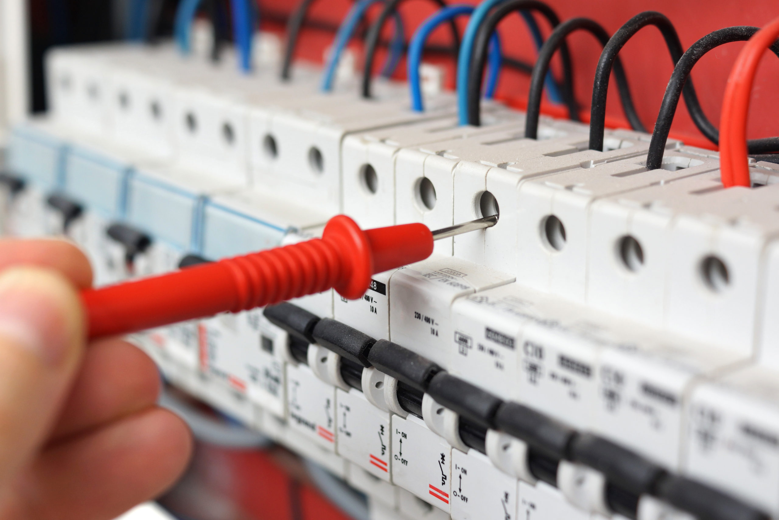 Hand of an electrician with multimeter probe